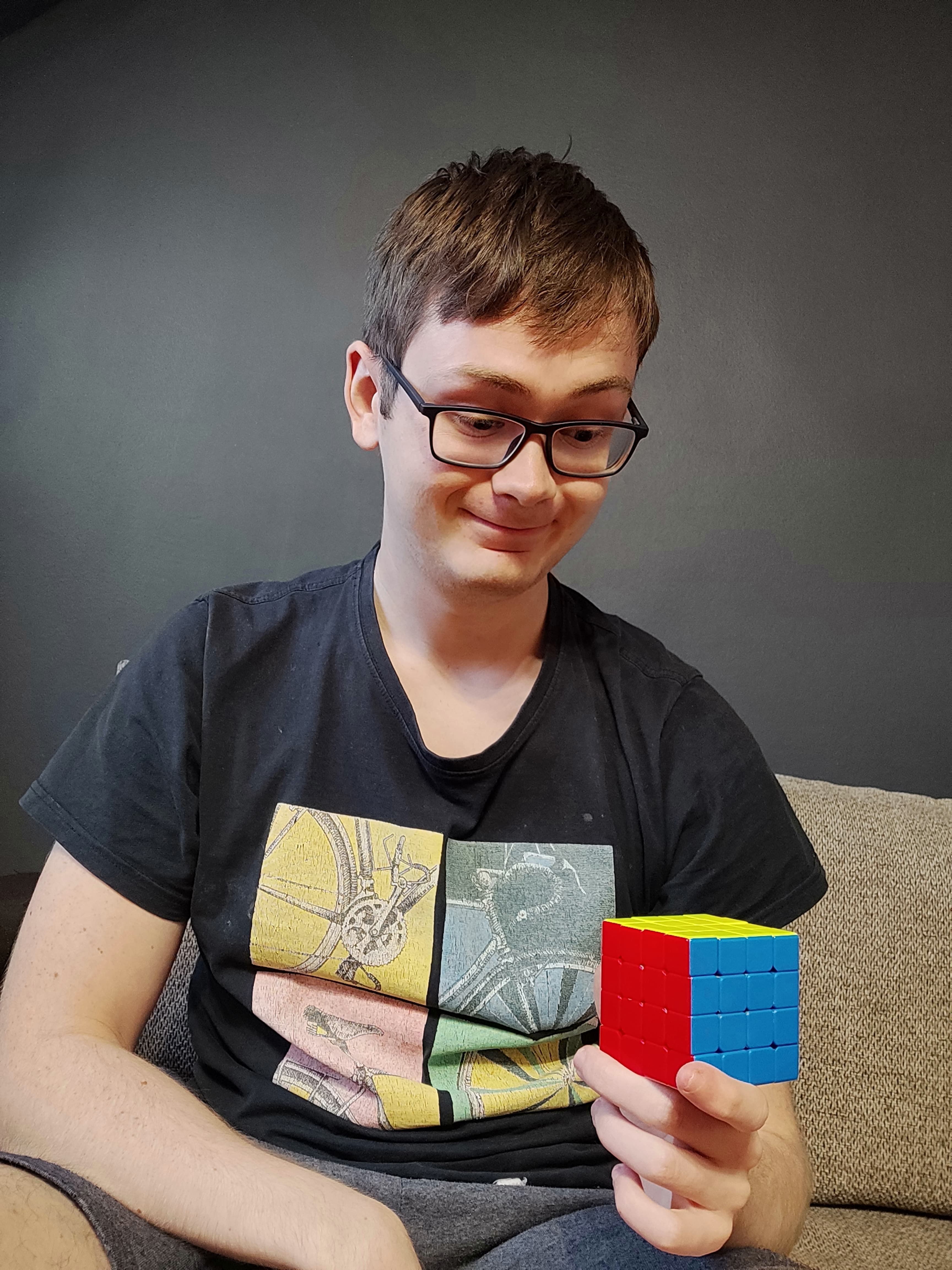 Mężczyzna trzyma w ręcę ułożoną kostkę 4x4.