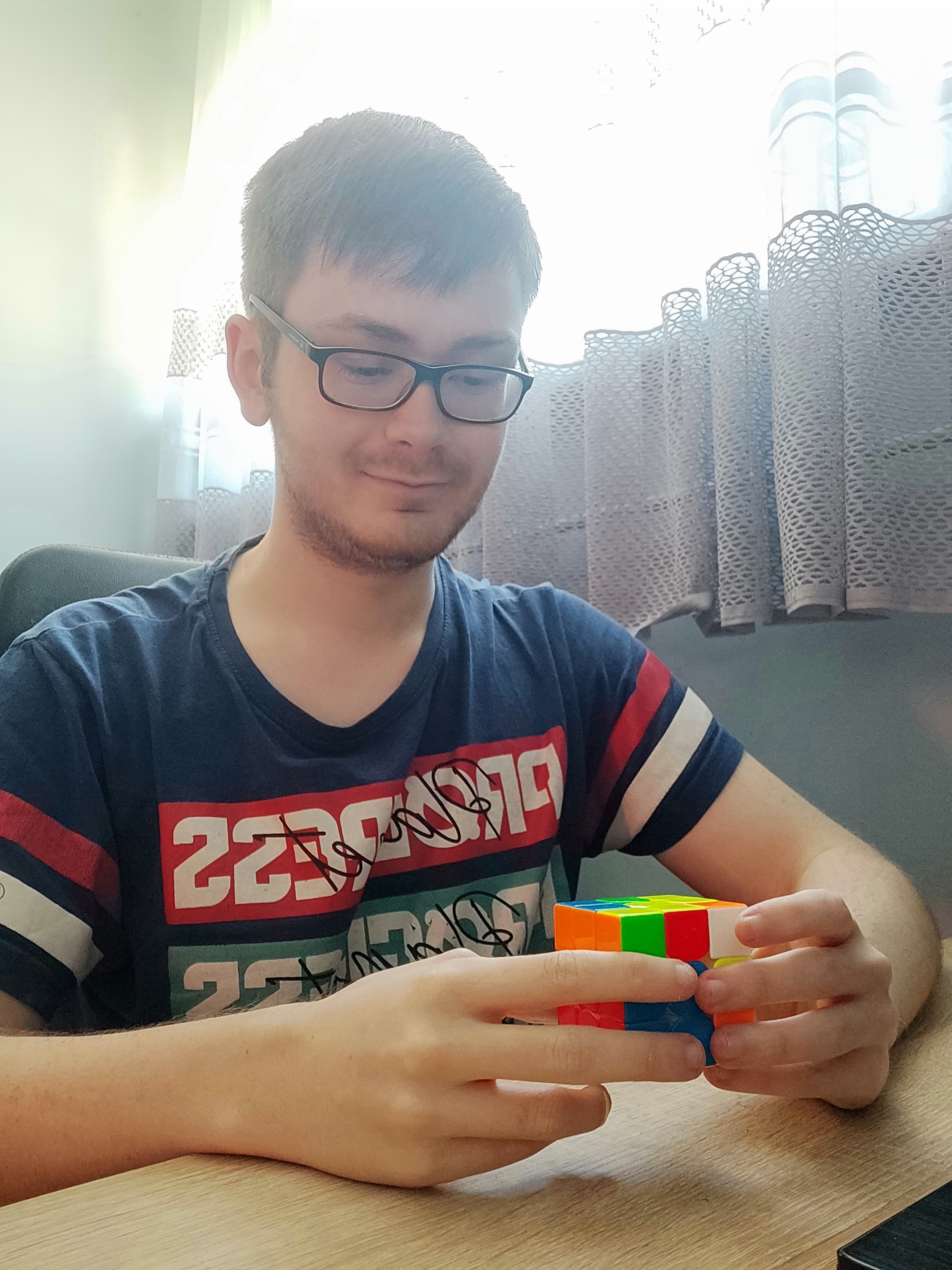 Mężczyna układający kostkę Rubika.